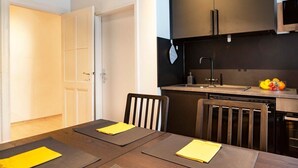 A compact kitchen with dark cabinets, a sink, and a fruit bowl on the counter.