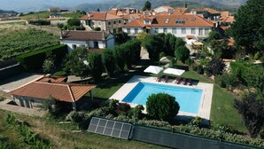 A residential area with a swimming pool, solar panels, and a view of distant mountains.