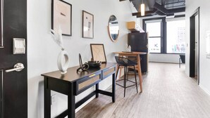 Een moderne kantoorruimte met een bureau, stoel, een lijst met kunst en een spiegel aan de muur.