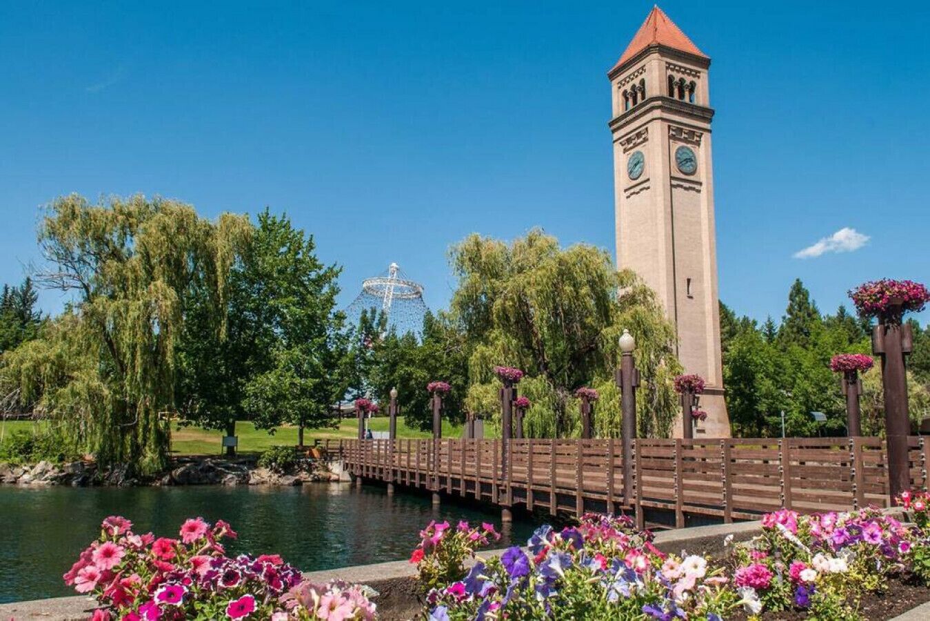 A park with a bridge, a tower, and a Ferris wheel.