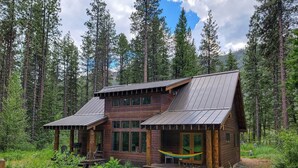 A cabin with a porch, large windows, and a hammock. - Triple J Cabin (Mazama)