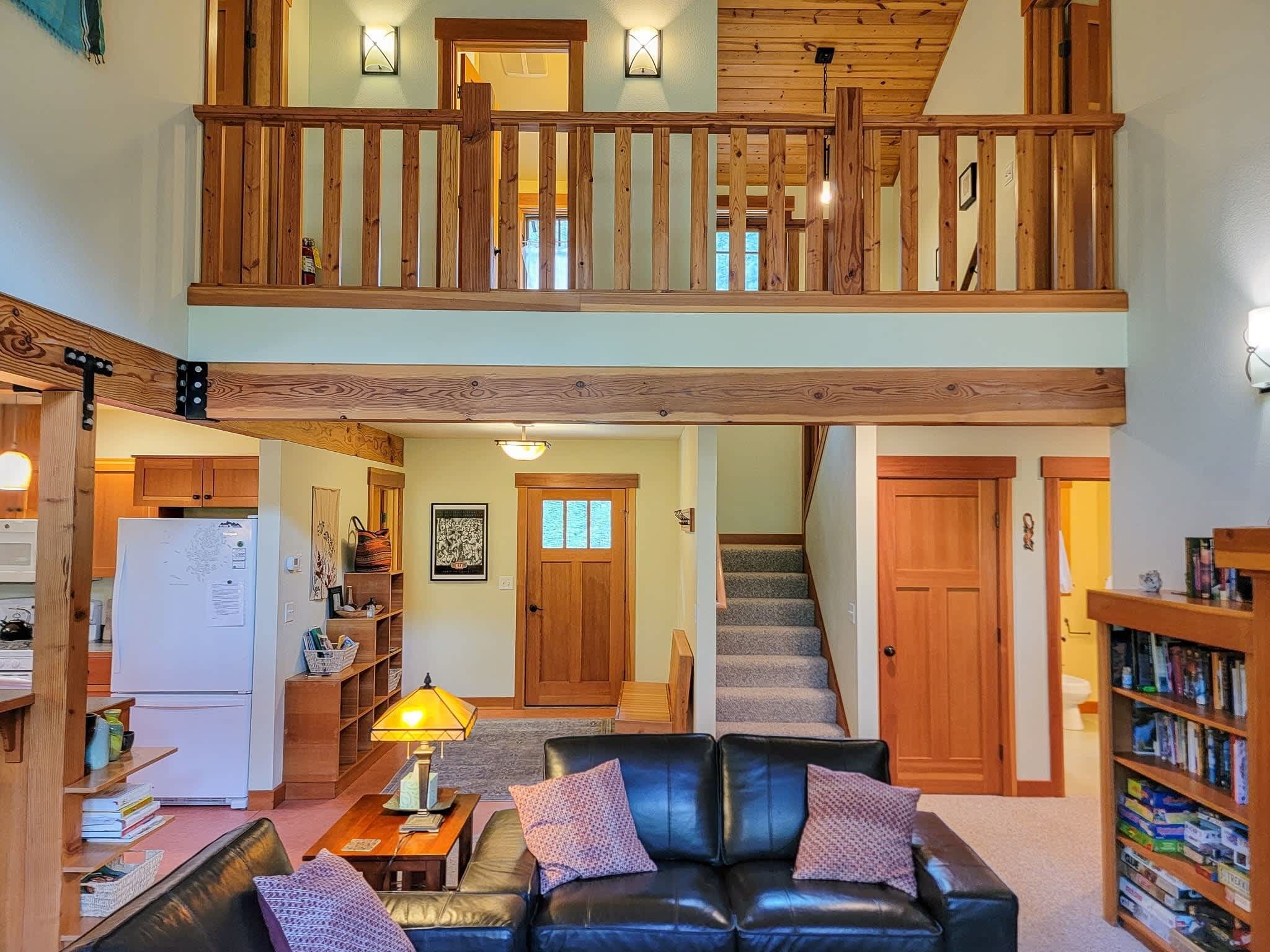 Una casa de dos pisos con sala de estar, cocina y una escalera que conduce al piso superior.