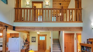 A two-story house with a living room, kitchen, and a staircase leading to the upper floor. - Triple J Cabin (Mazama)