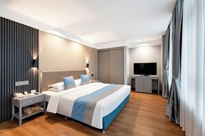 Ein modernes Hotelzimmer mit einem großen Bett, Nachttisch und Fernseher.