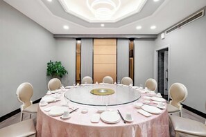A conference room with a round table, chairs, and a glass partition. - Sports International Hotel (Kunshan)