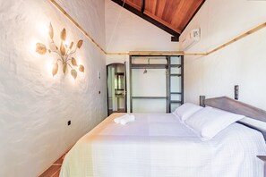 Un dormitorio moderno con una cama grande, un aplique de pared y un armario de puertas correderas.