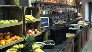 A buffet area with various fruits and desserts displayed on shelves and counters. - Village vacances Neaclub - La Pulka (Valloire)