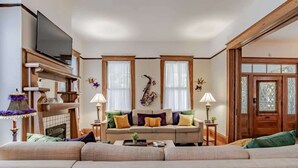 Un salon comprenant un canapé, un téléviseur et une cheminée.
