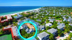 An aerial view of a coastal residential area with a beach, houses, and a highlighted section of a community with a central courtyard. - 2-Min Walk to Holmes Beach - Walk to Shops & Dining - Quiet Tropical Townhouse (Holmes Beach)