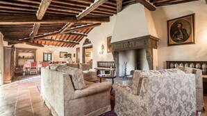 Un salón amplio con techos de madera altos, chimenea y asientos cómodos.