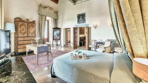 Une chambre spacieuse avec un grand lit, une commode, un bureau et un téléviseur.