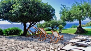 A stone patio with lounge chairs, a small pool, and a view of the ocean. - VILLA MARATEA - Six Bedroom Villa, Sleeps 12 (Maratea)