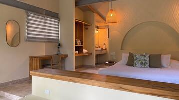 Ein Schlafzimmer mit Bett, Nachttisch, Lampe und einer hölzernen Bank.