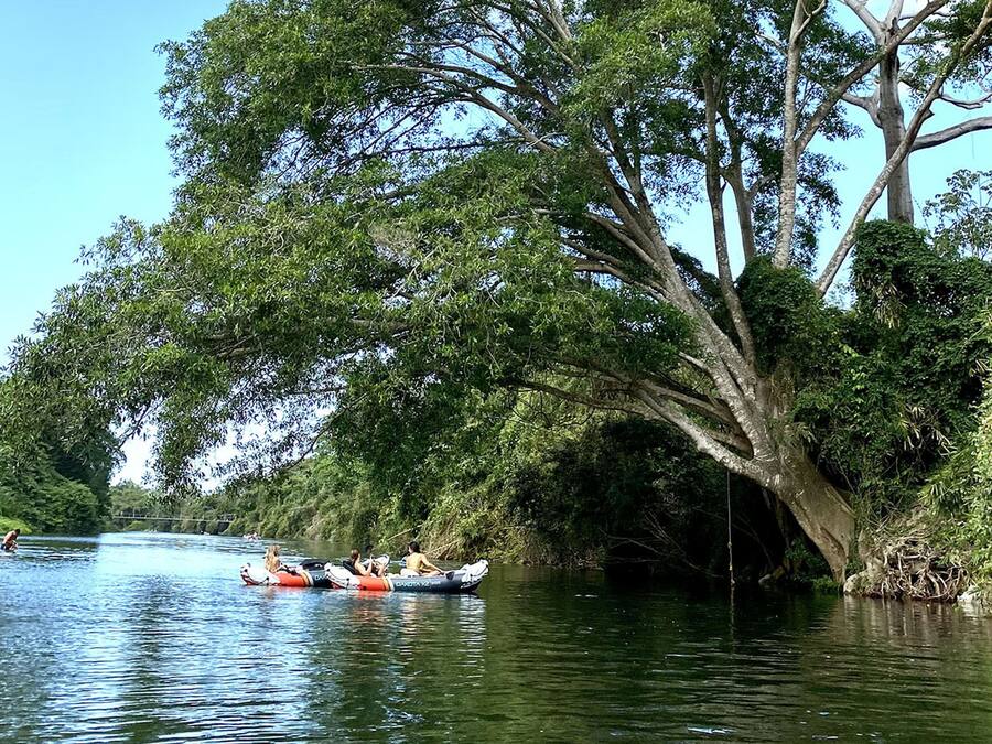 Escena de un río con una barca transportando personas.