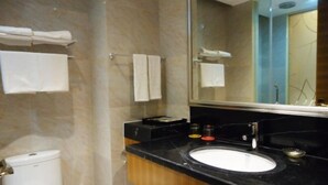 A modern bathroom with a toilet, a sink, and a mirror. - Shibang Business Hotel (Ningbo)
