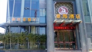 A hotel with a modern glass facade and a traditional Chinese architectural element. - Shibang Business Hotel (Ningbo)