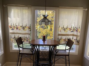 Sit around the round table in this dining area, surrounded by natural views of a tree with vibrant foliage.