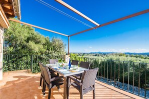 Enjoy al fresco dining on the terrace with a view of the lush landscape and distant hills.
