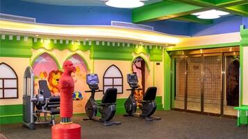 A gym with exercise equipment, a lion statue, and a colorful wall design.