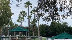 A park with a gazebo, benches, and a railing overlooking a body of water.