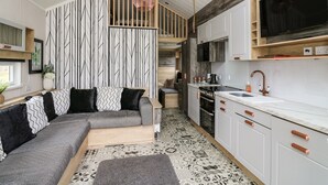 Una cucina moderna con mobili bianchi, un piano cottura nero e un'ampia finestra.