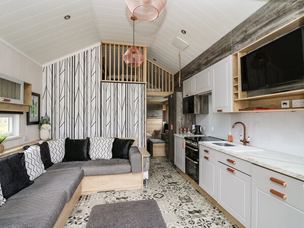 A modern kitchen with white cabinets, a black stove, and a large window.
