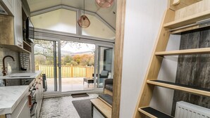 Una cucina funzionale con un'ampia porta scorrevole in vetro che dà su una terrazza, una panca integrata e un termosifone.