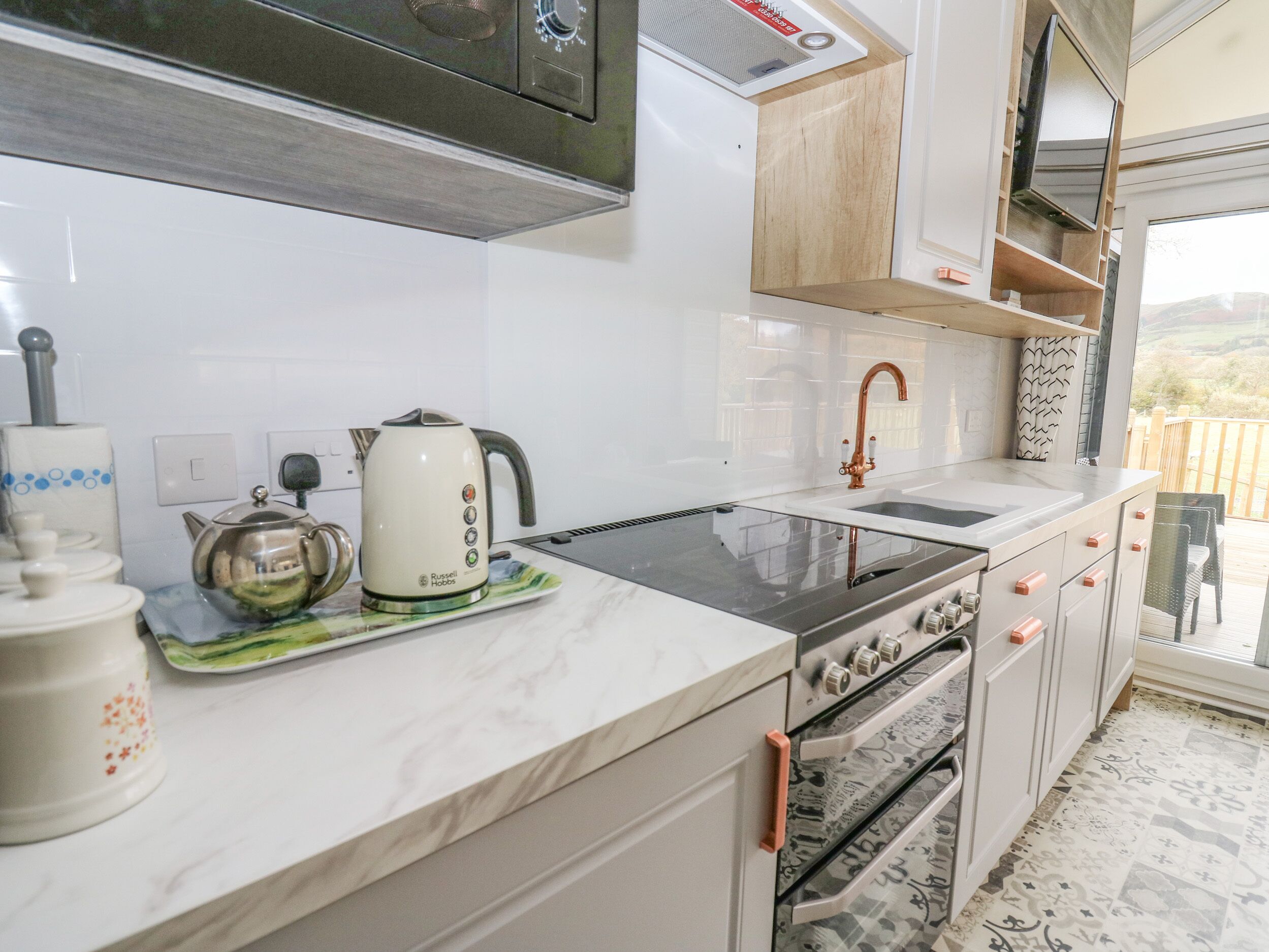 Una cocina moderna con horno empotrado, estufa y pileta.