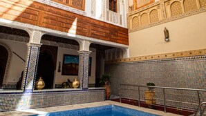 A courtyard with a swimming pool, ornate arches, and a tiled wall. - Riad Sayeda Al Hora (Fes)