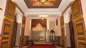 An ornate interior with intricate tile work, a red carpet, and traditional furnishings. - Riad Sayeda Al Hora (Fes)