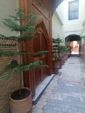 A narrow alley with a wooden door and potted plants. - Riad Sayeda Al Hora (Fes)