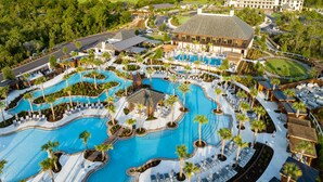A resort with multiple swimming pools, a large building, and a surrounding forest. - Camp Creek Inn (Panama City Beach)