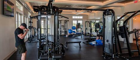Una palestra con diverse attrezzature per esercizi, tra cui macchinari per pesi e pesi liberi.