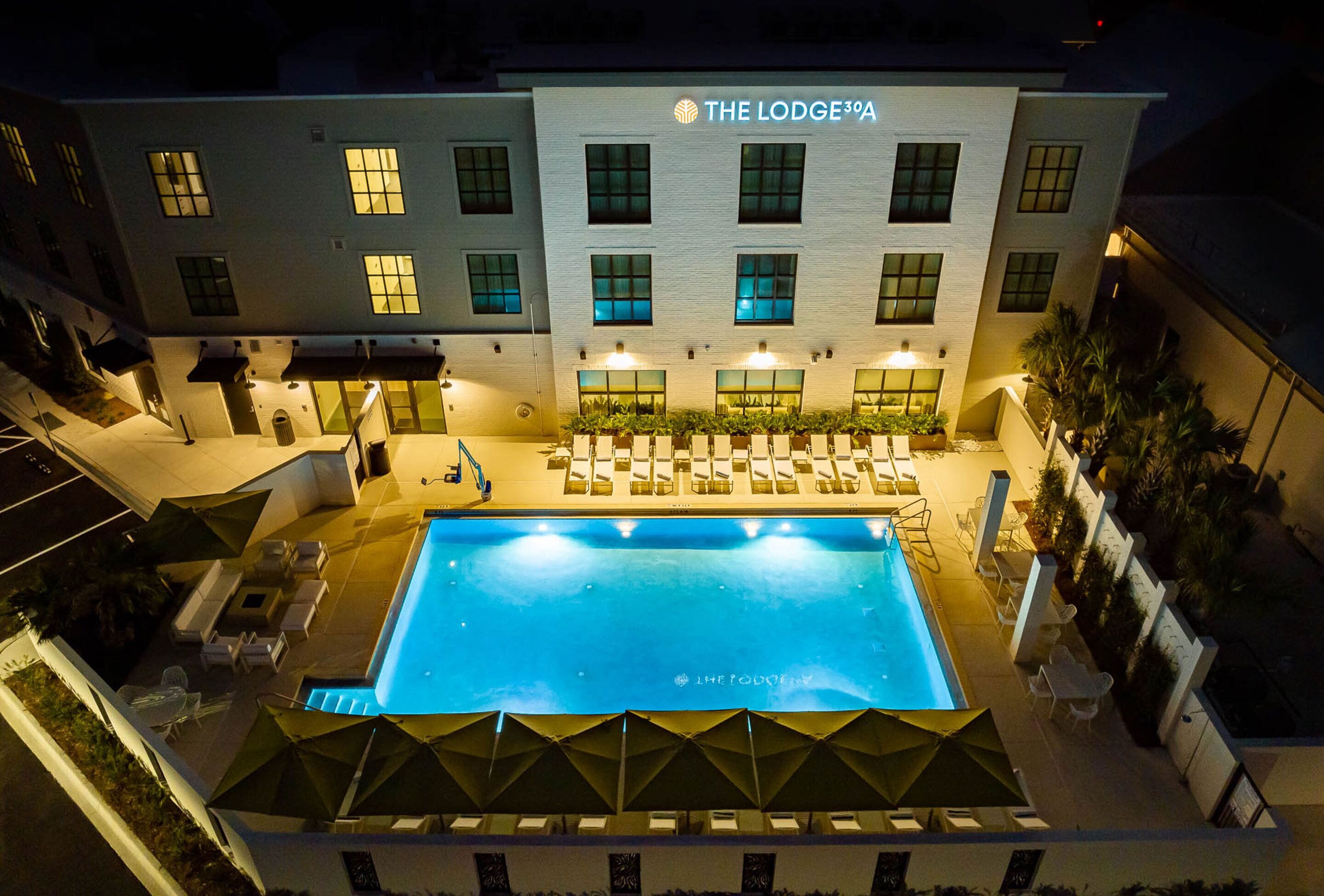 Un hotel con piscina, mobiliario exterior y un letrero que dice "The Lodge 3A".
