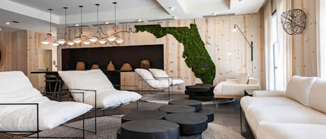 A modern living room with a sofa, chairs, and a unique wall mural.