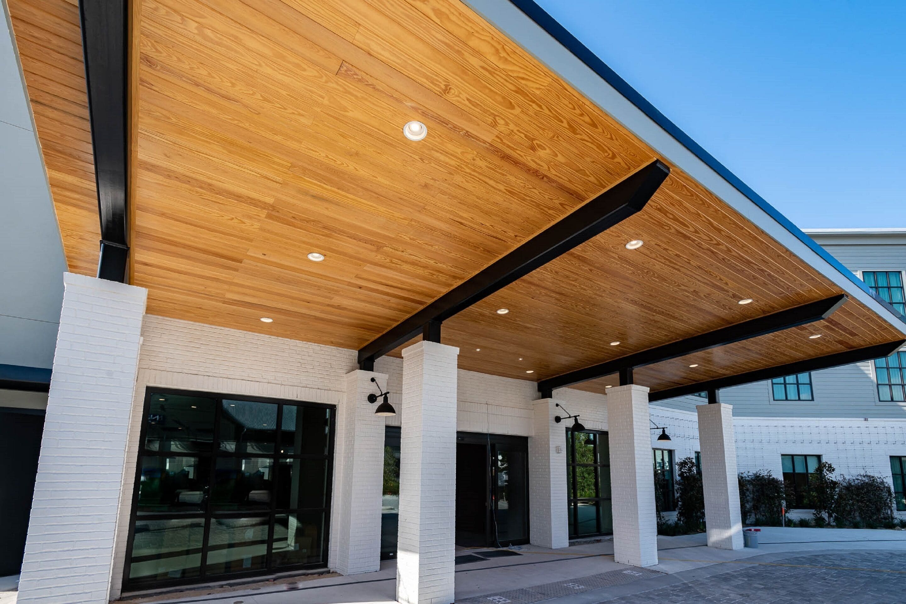 A modern building with a wooden ceiling and white brick walls.