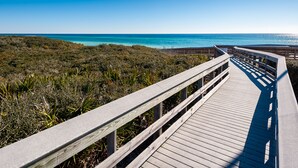 A wooden boardwalk leading to a beach with clear blue water and a clear sky. - The Lodge 30A (Santa Rosa Beach)