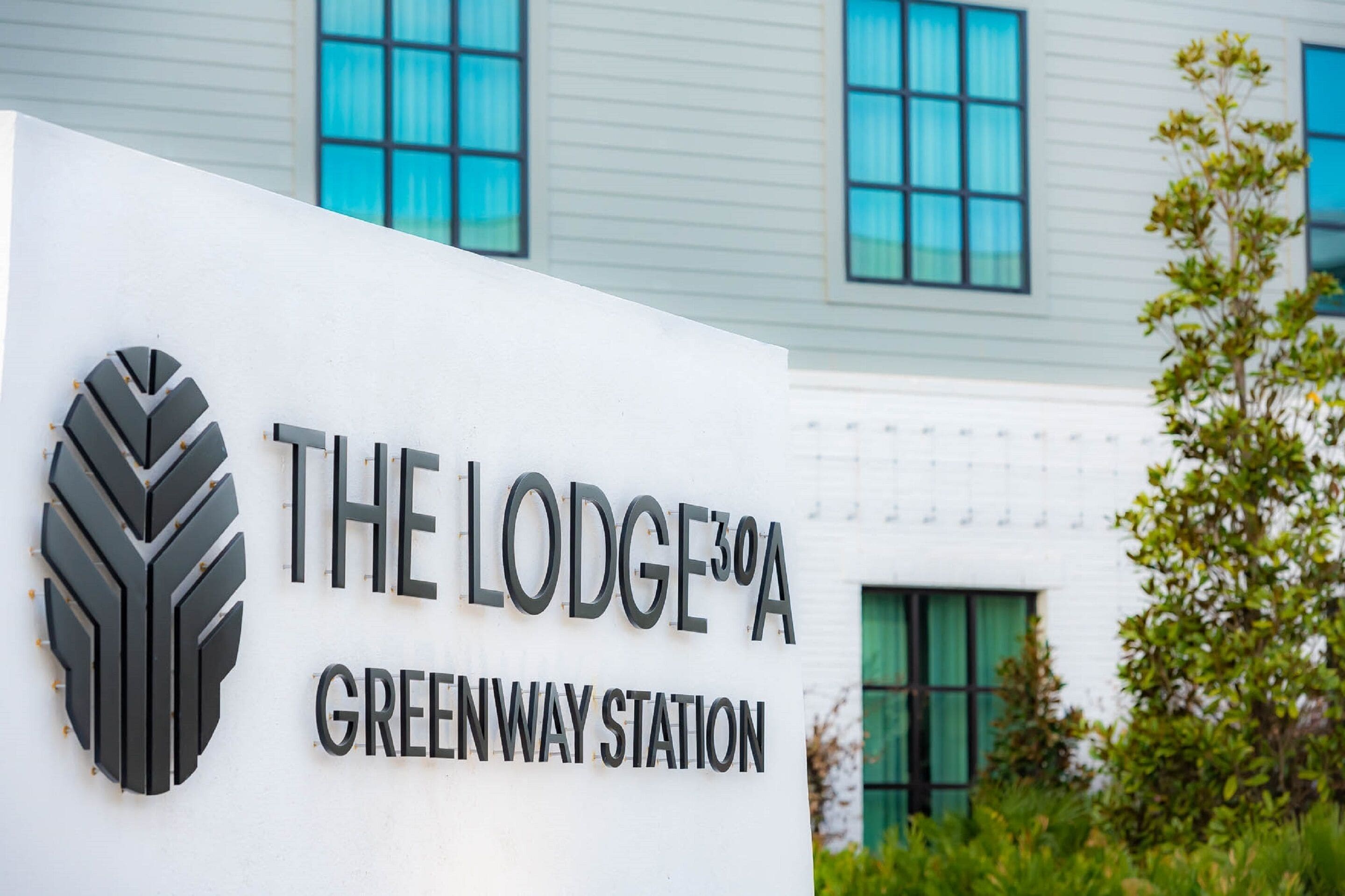 A sign for The Lodge 3rd A Greenway Station.