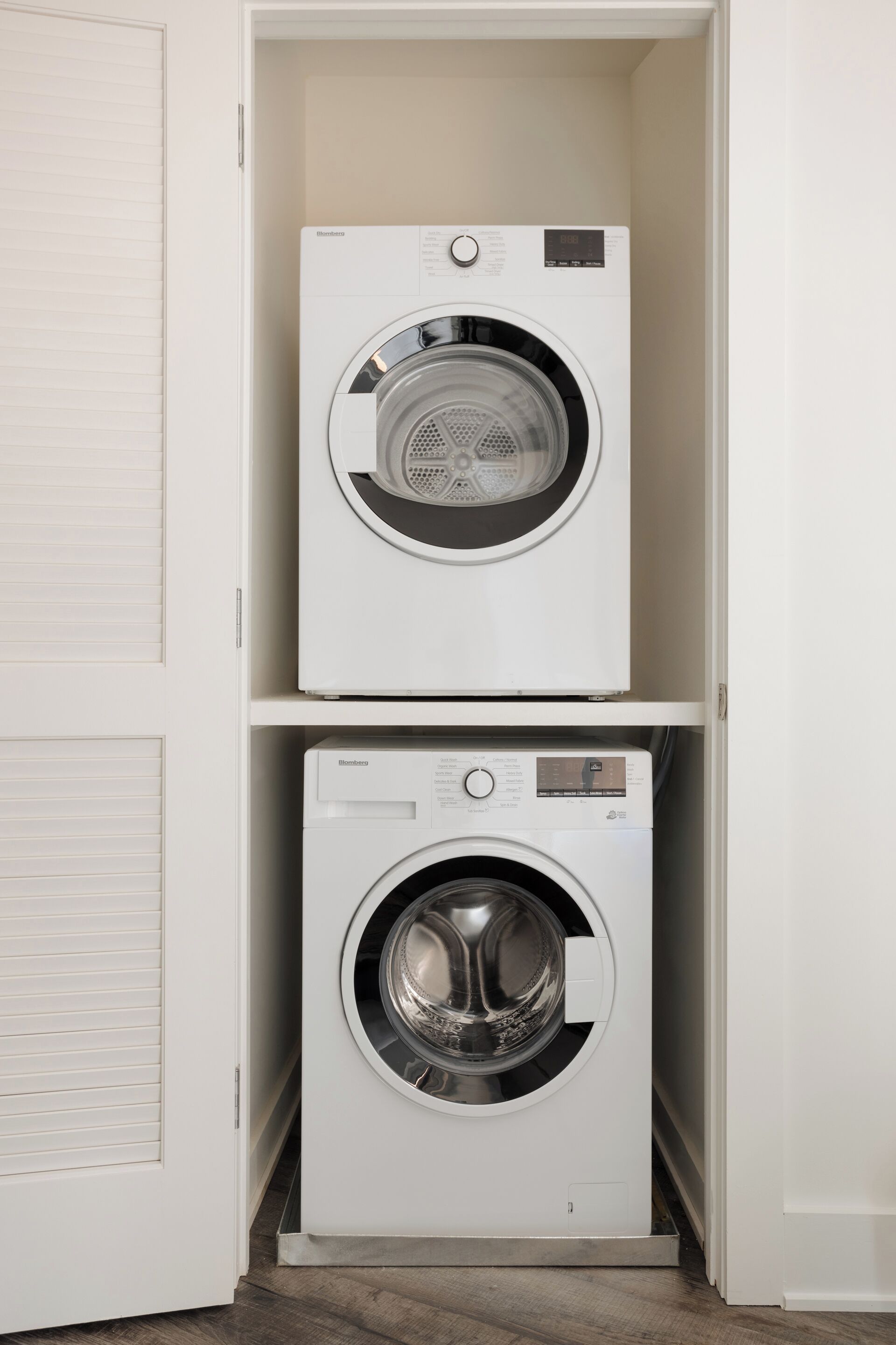 A laundry room with two stacked front-loading washing machines.