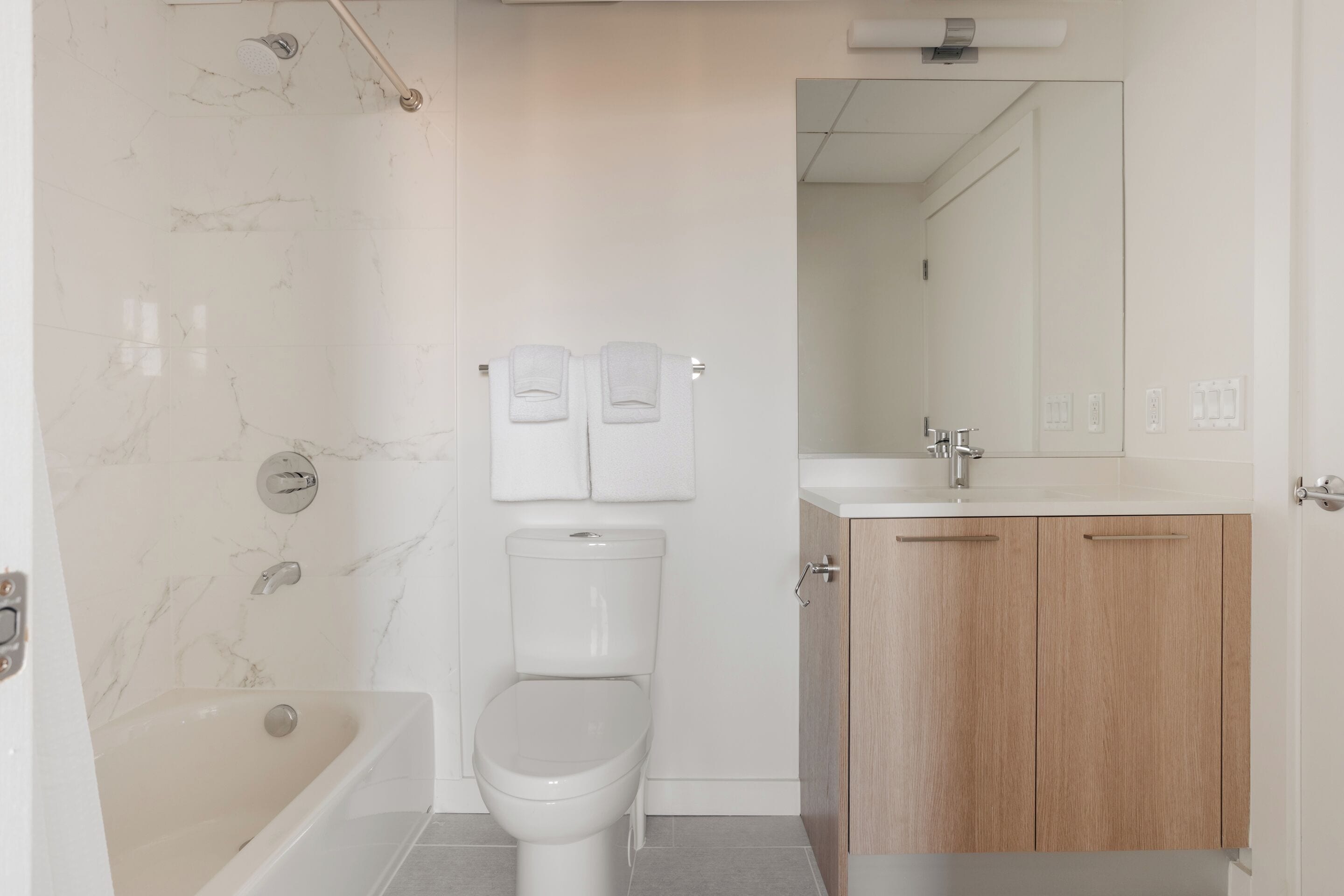 Une salle de bain moderne avec une baignoire, des toilettes et des meubles en bois.