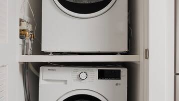 Two stacked front-loading washing machines in a laundry room.