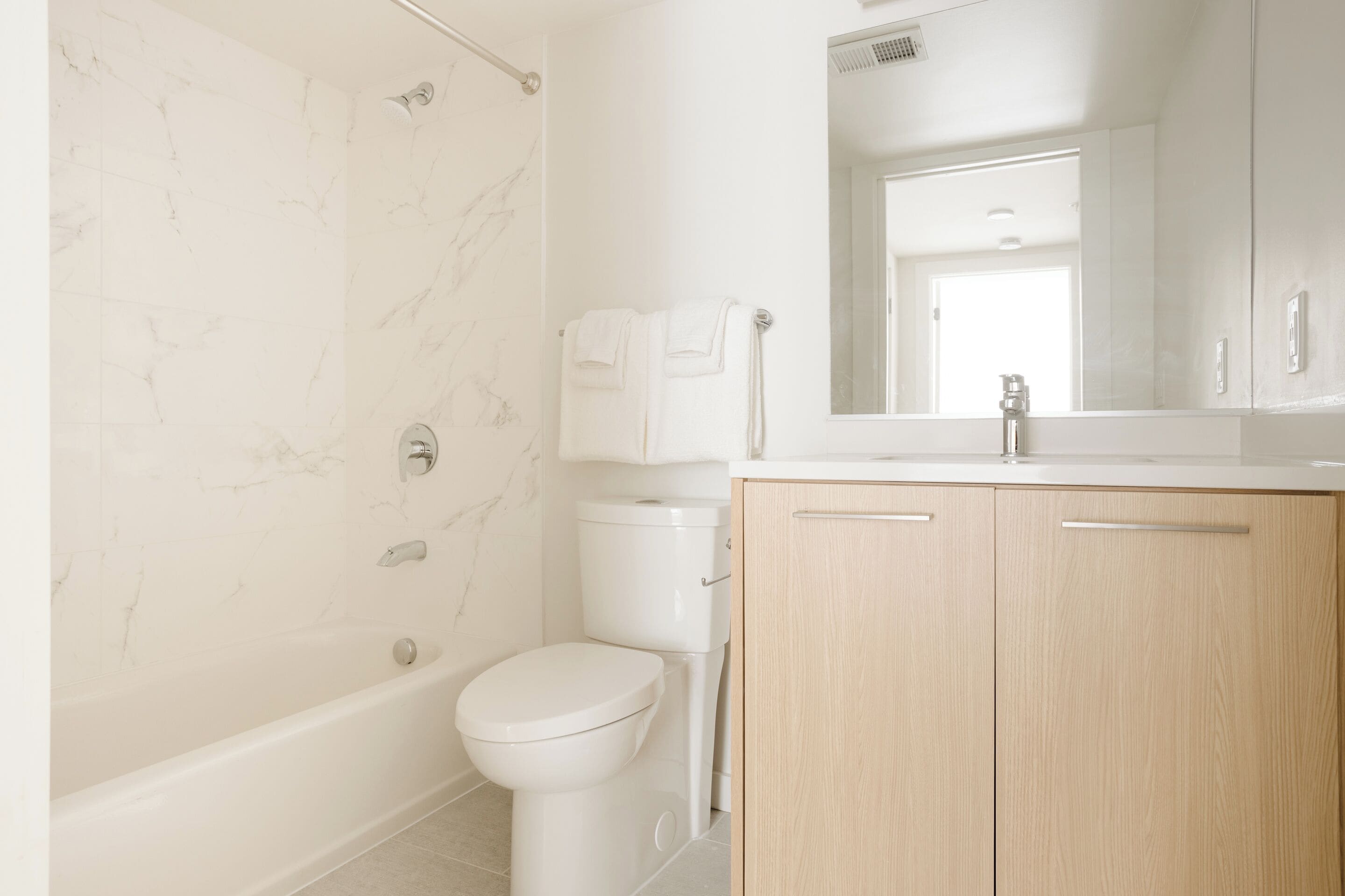 Une salle de bain moderne avec une baignoire, des toilettes et des meubles en bois.