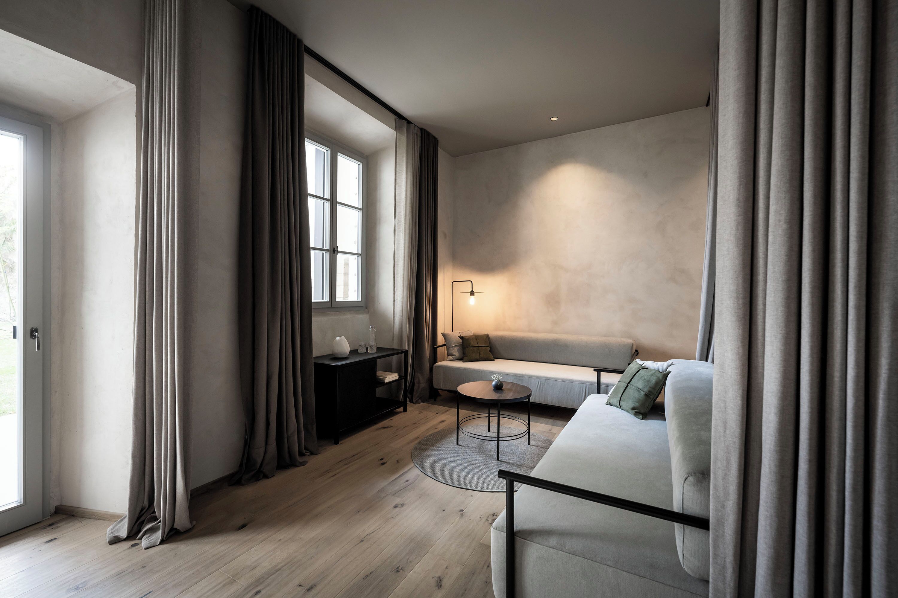 Un salon moderne avec un canapé, une table basse et une lampe.