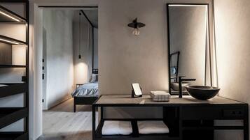 A modern bedroom with a bed, bedside table, and a large mirror.