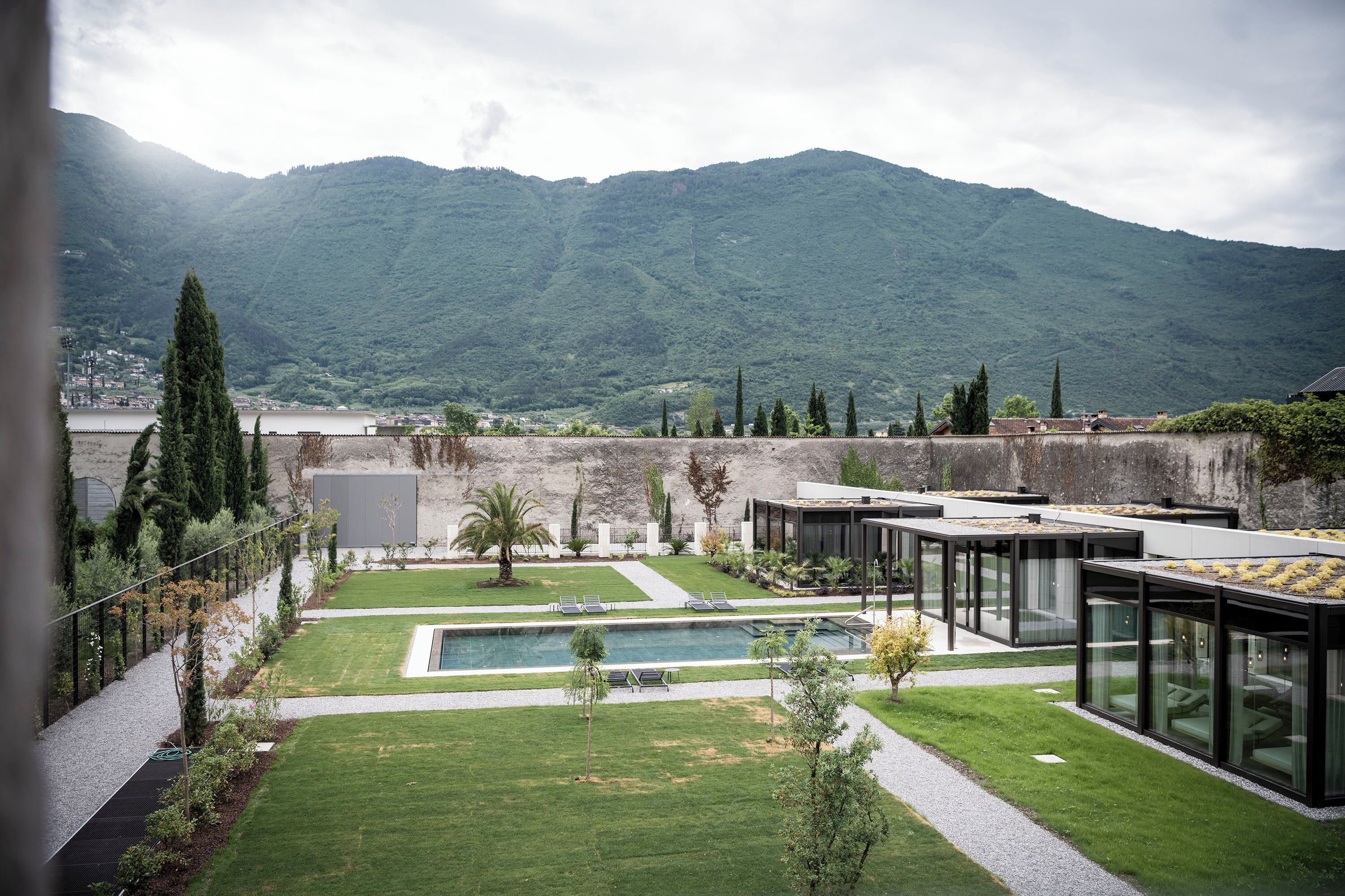 Zona exterior moderna amb piscina, seients i un paisatge de muntanya de fons.