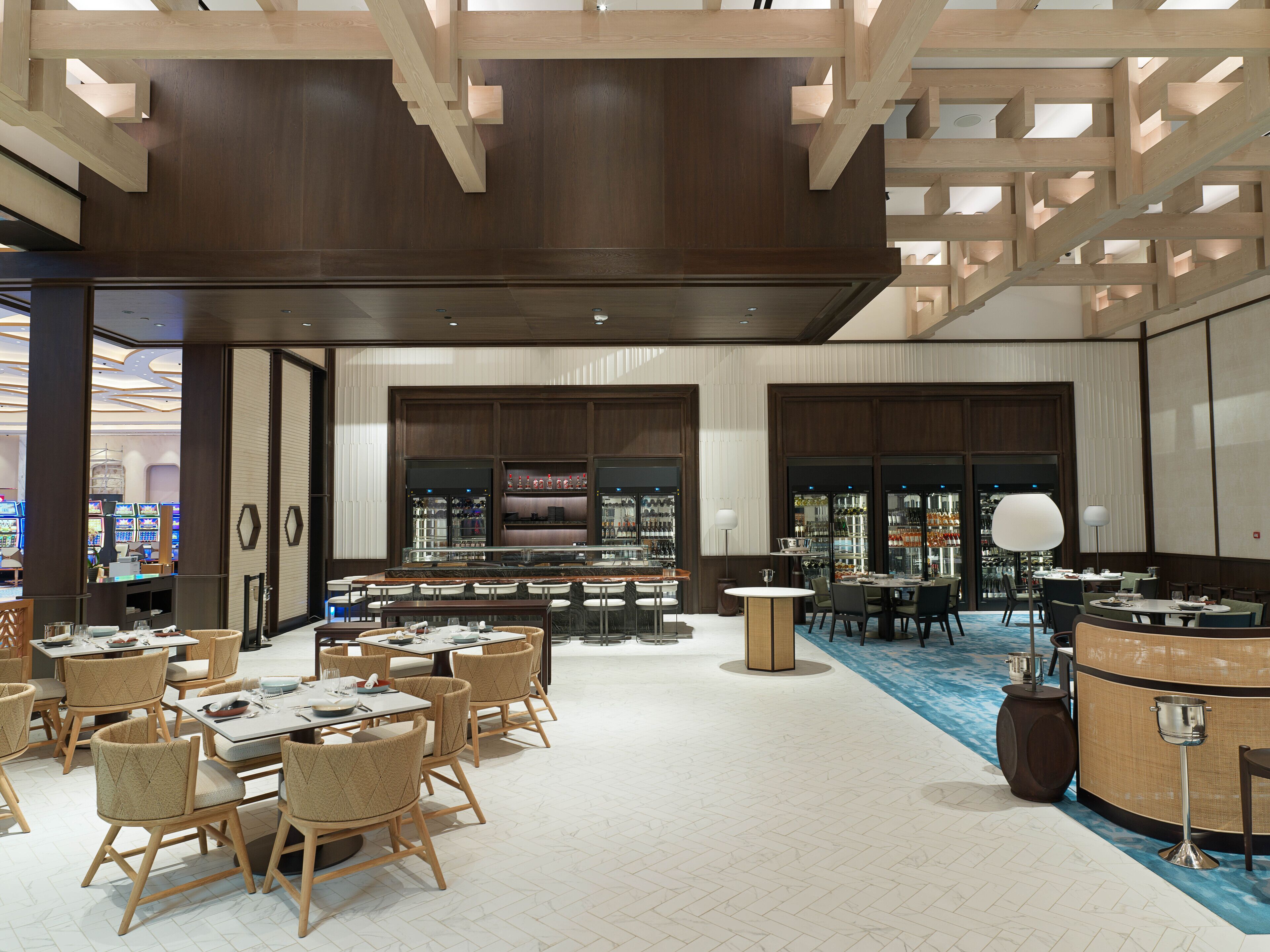 A spacious hotel lobby with multiple seating areas, a bar, and a reception desk.