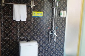 Um banheiro com chuveiro, porta-toalhas e uma placa com caracteres chineses.