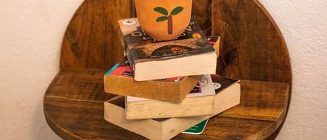 A wooden shelf with a potted plant and stacked books.