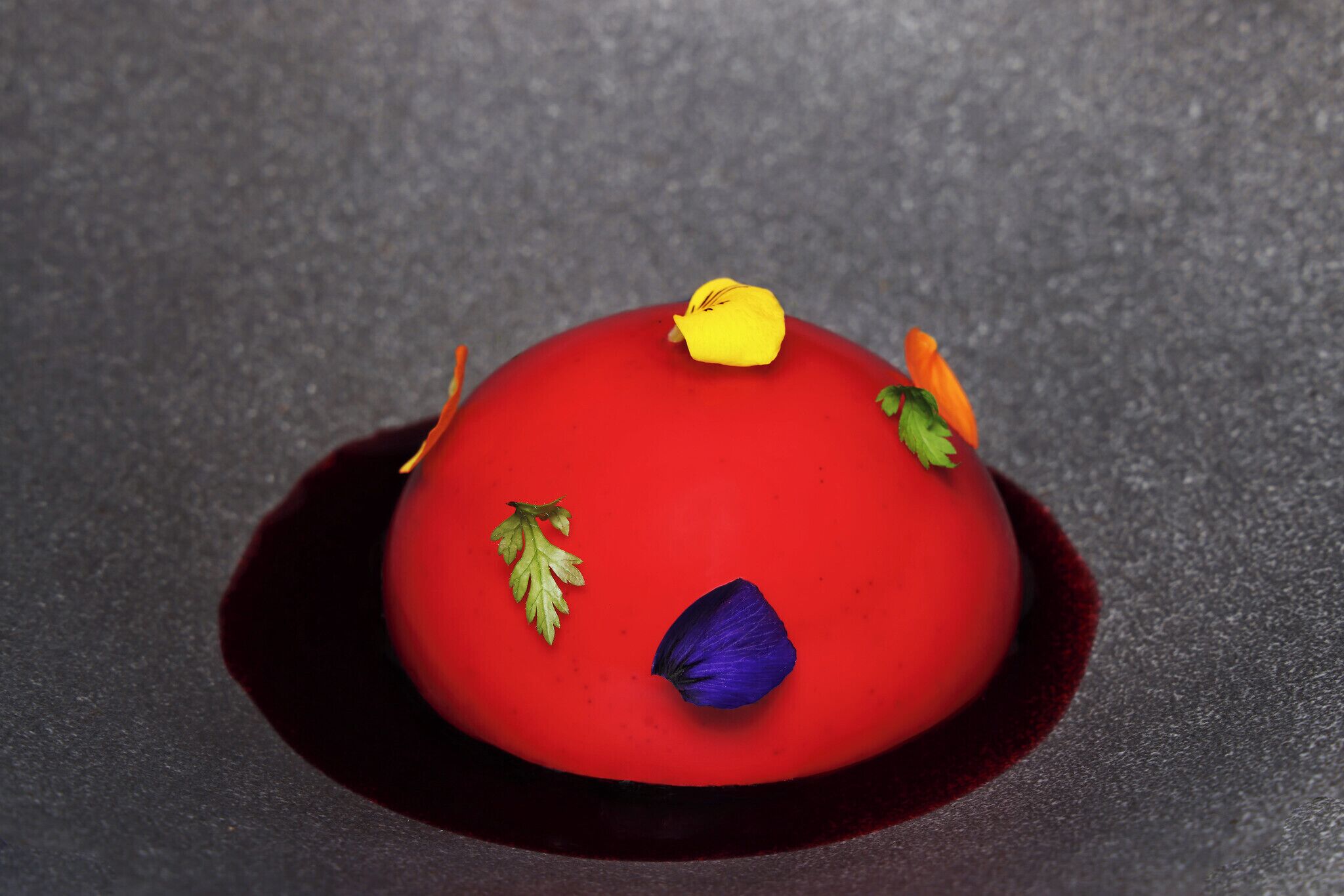 Ein Dessert mit roter Basis und dekorativen Elementen.