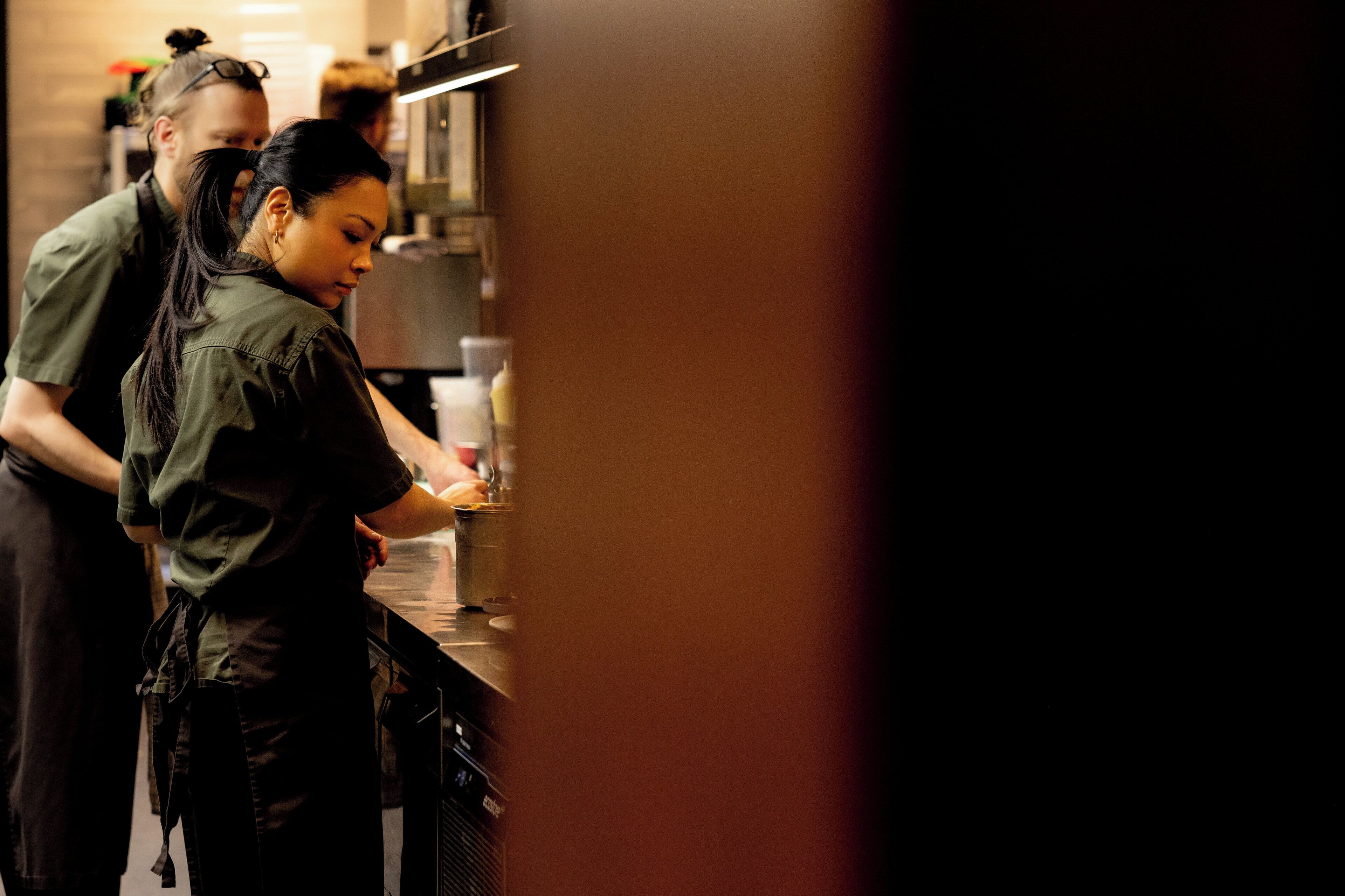 A kitchen area with a person preparing food.